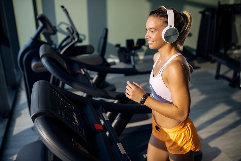 [fpdl.in]_happy-athletic-woman-with-headphones-jogging-on-running-track-in-a-gym_637285-8566_medium.jpg