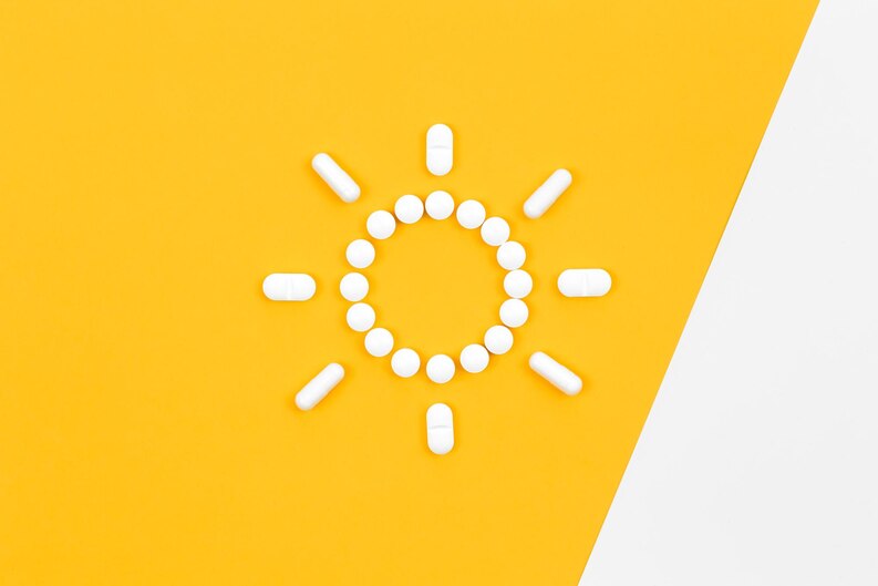 [fpdl.in]_pills-in-the-shape-of-the-sun-on-a-yellow-background-flat-lay_169016-27360_medium.jpg